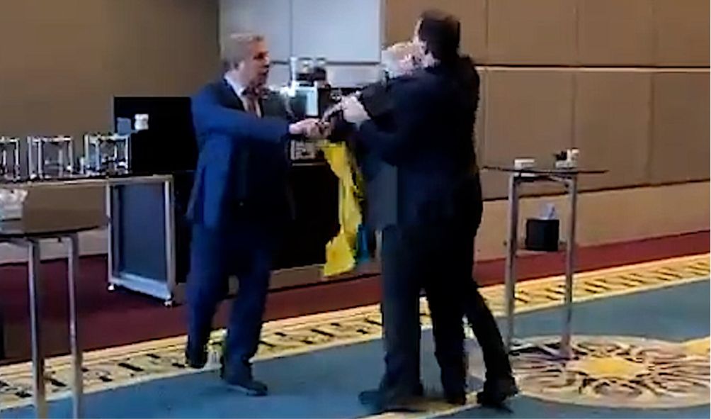 Russian and Ukrainian delegations engage in a physical fight over a flag